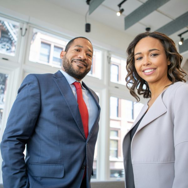 professionally dressed man and woman smiling in the office