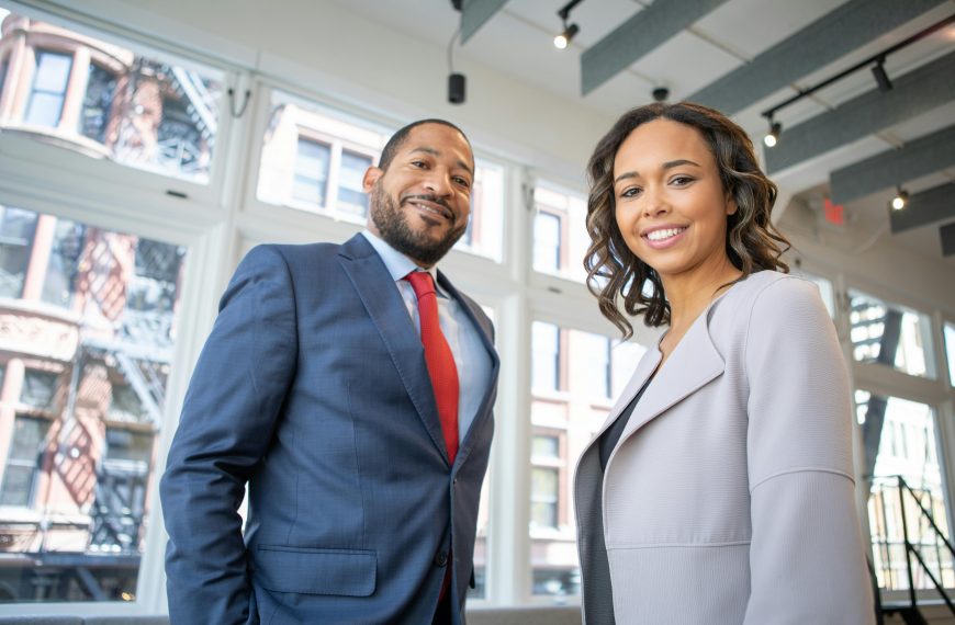 professionally dressed man and woman smiling in the office