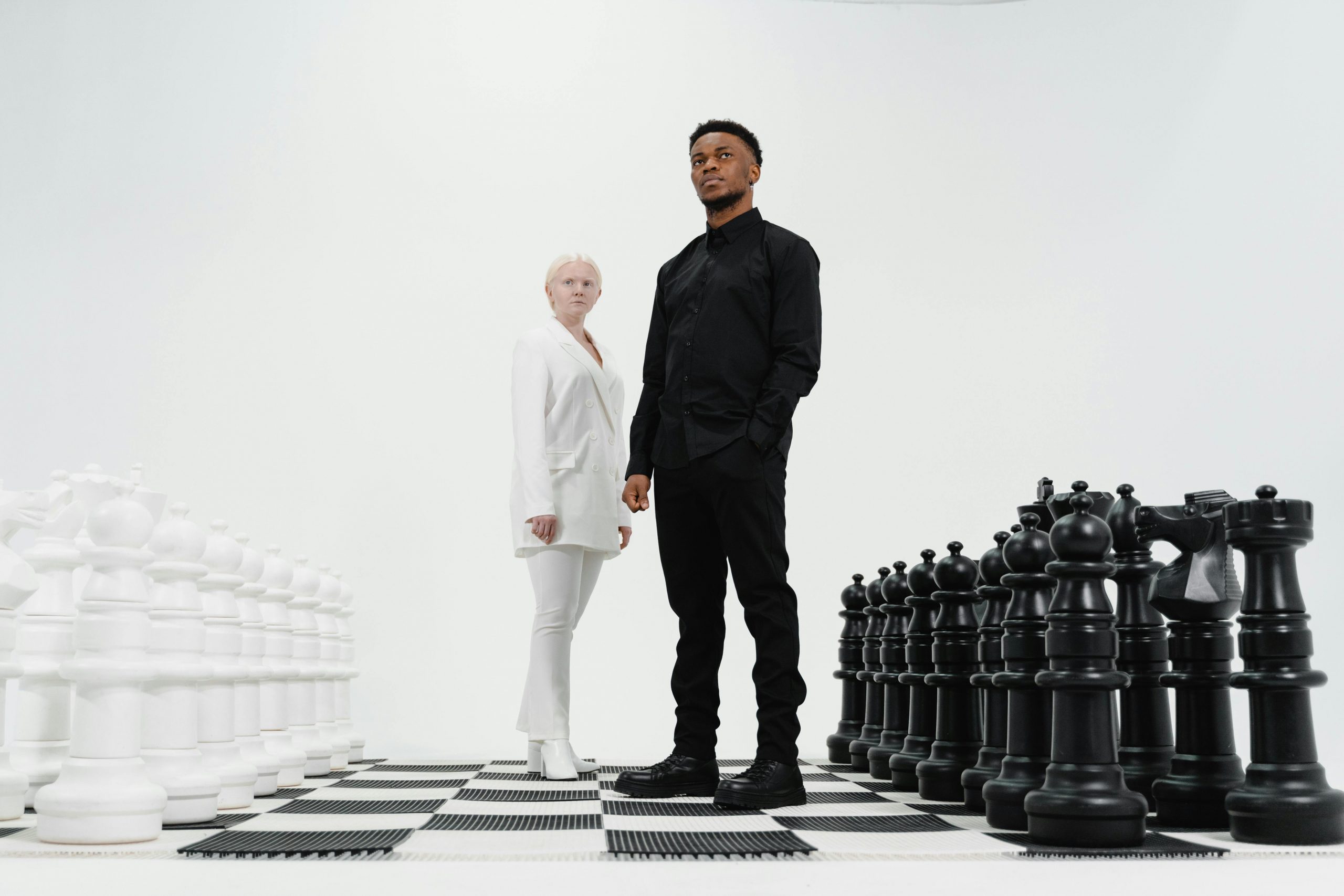 professionally dressed man and woman standing on a life-size chessboard